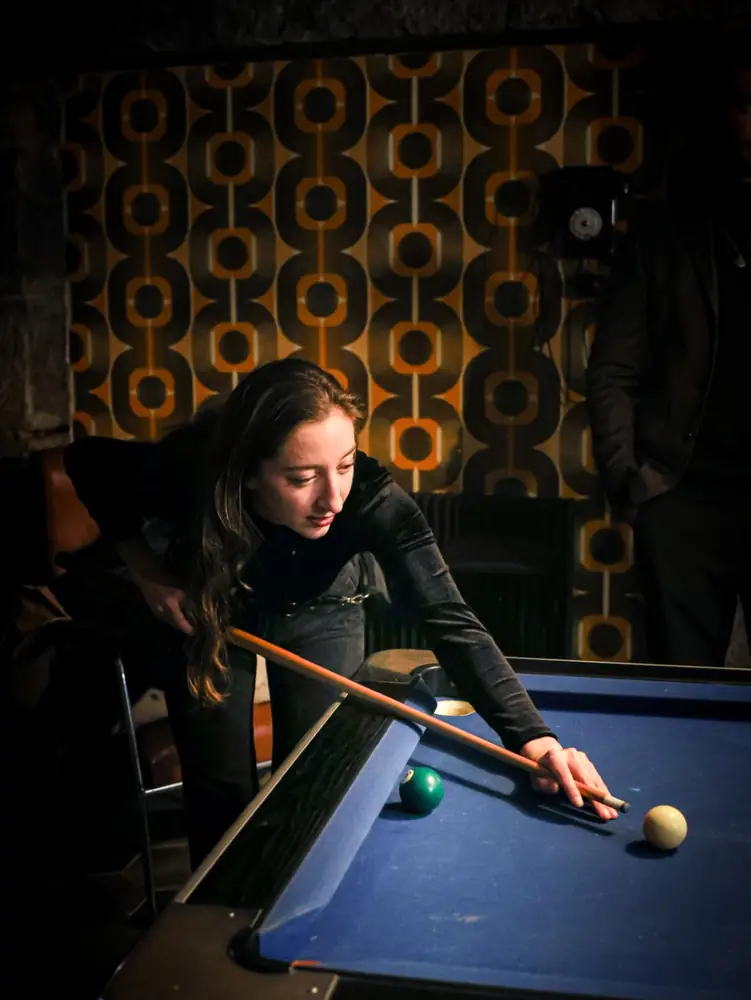 Joueuse au billard dans la salle de l'étage